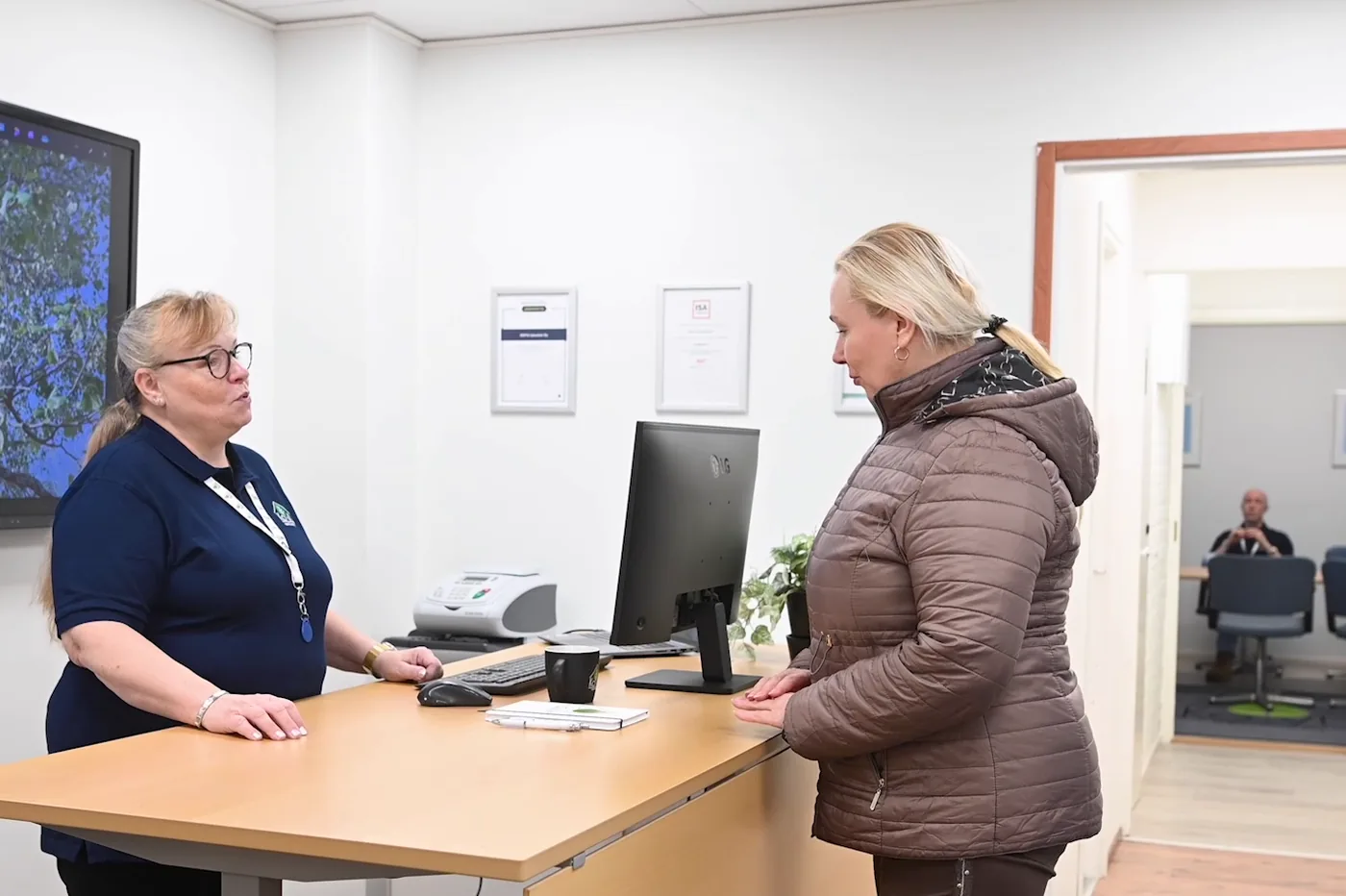 Koivun isännöitsijä palvelee asiakasta toimiston palvelutiskillä